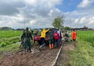Satgas TMMD Dan Warga Mendorong Mobil Matrial Terjebak Di Lumpur