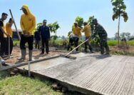 Anggota Satgas TMMD Menggaris Jalan Beton Supaya Tidak Licin